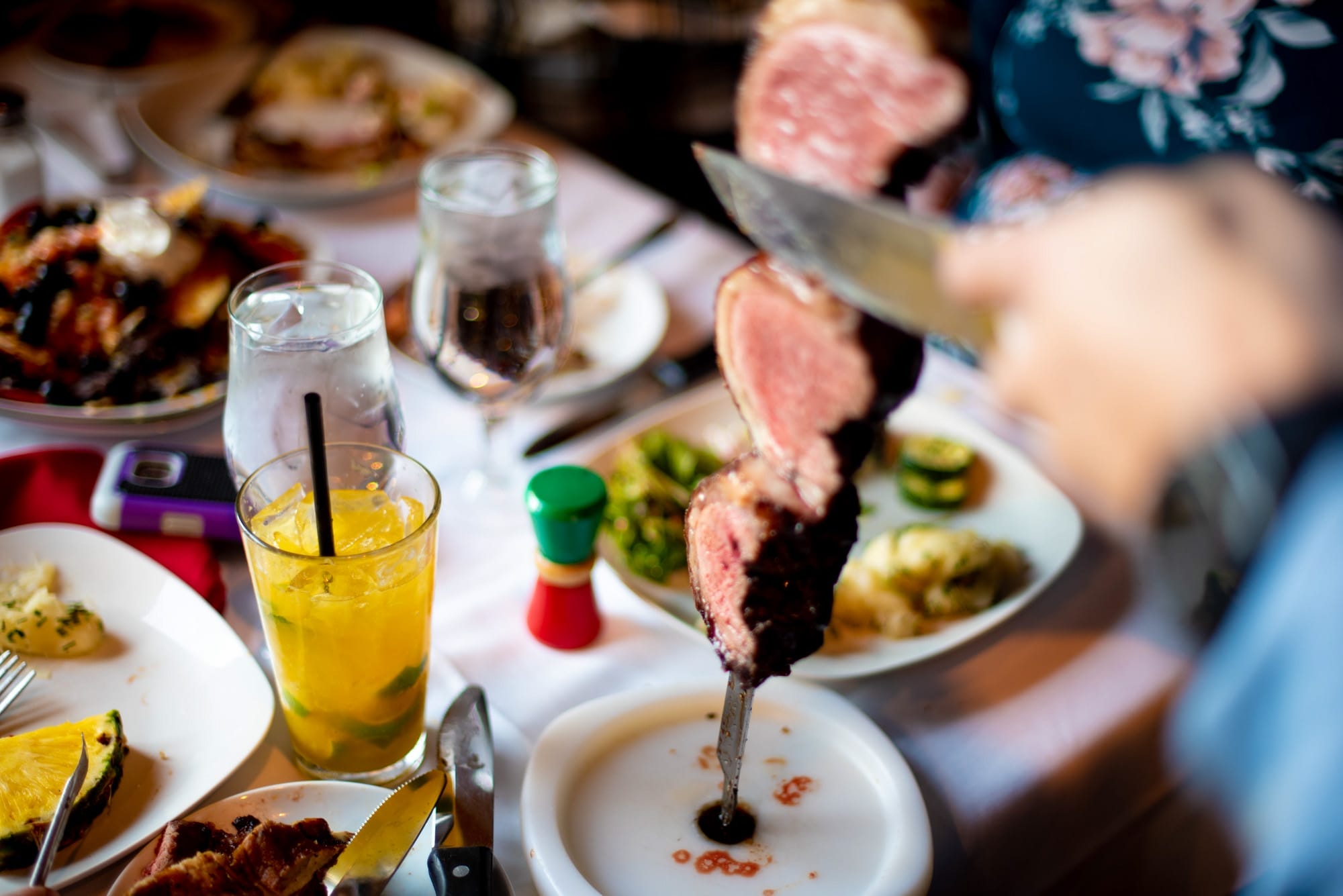 Gaucho serving meat off a skewer on a table
